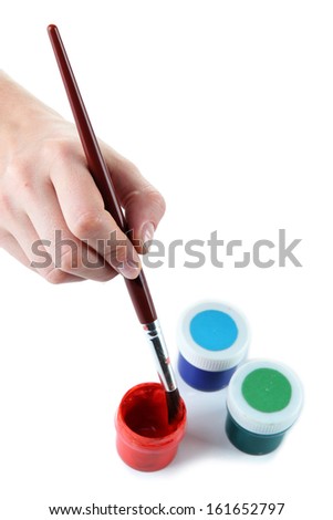 Paint brush in hand and multicolored paints isolated on white