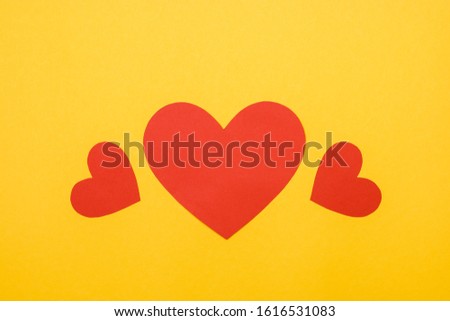 three decorative red hearts on yellow background