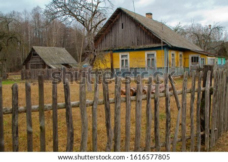 Russian style village. Wooden farmhouse behind a wooden picket fence. Abandonned concept, farm in Belarus