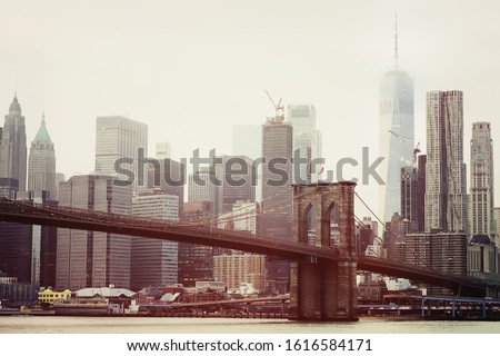 Toned photo of skyscrapers of Manhattan and Brooklyn bridge at winter day. Famous bridge. Postcard view of New York.