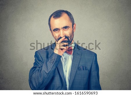 Businessman in thoughts looking at you camera pensive. Mixed race bearded model isolated on gray background with copy space. Horizontal image.