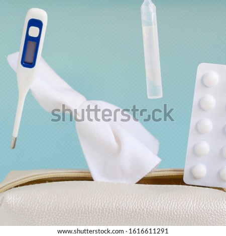 levitation of thermometer, pills, wipes and spray for the nose on a blue background.  flu treatments, flat lay