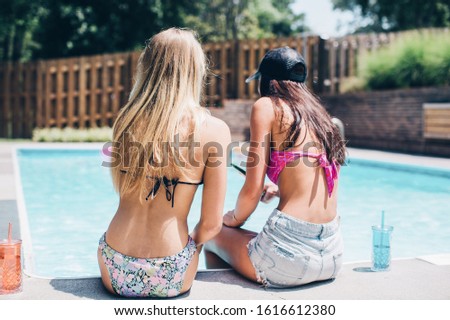 Two Girls Sitting By the Pool