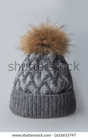 Warm winter gray hat with fur on a white background