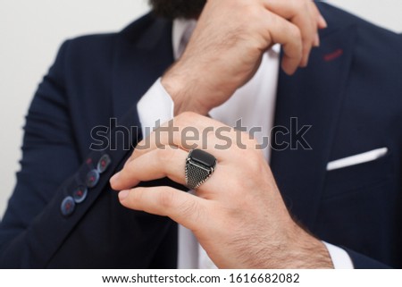 
Image of male model dressed in suit and attentive on jewelry