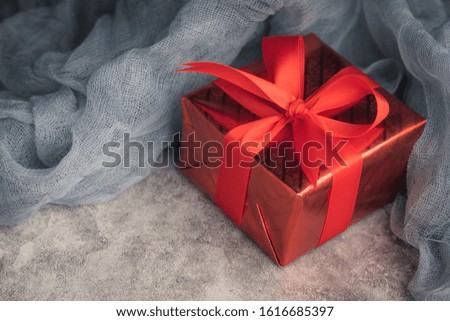 Red gift box on black background with copy space for your greeting.