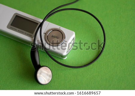 Digital audio player on green background.