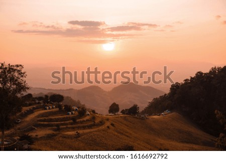 A front selective focus picture of sunset over touristic place at mountain range in summer of Thailand.