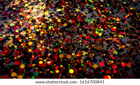 Colorful confetti background, bright and shiny on dark grey surface