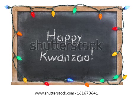 Happy Kwanzaa written in white chalk on a black chalkboard surrounded with lights isolated on white