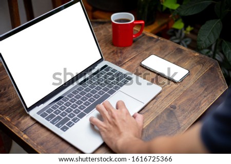 mockup image blank screen computer,cell phone with white background for advertising text,hand man using laptop texting mobile contact business search information on desk in cafe.marketing,design