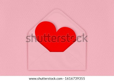 Red heart in envelope on pink background. love letter.