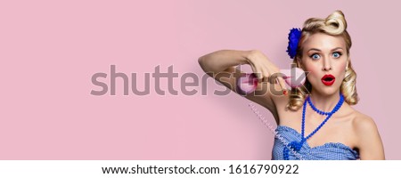 Shocked or very happy woman with phone tube. Pin up girl, keeping mouth open - unbelievable sales concept. Retro fashion and vintage. Pink rose background. Copy space for some text. 