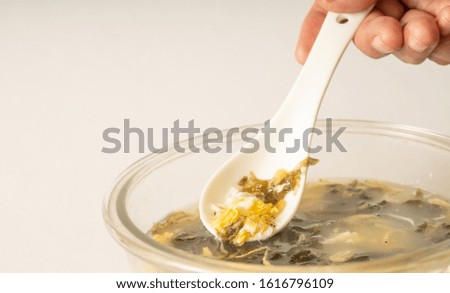 Seaweed egg flower soup in glass bowl on pure white background