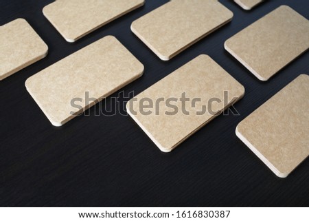 Photo of blank vintage business cards on black wood table background. Template for branding identity.