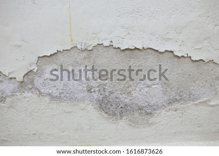 Rusty white paint peeling off from concrete wall