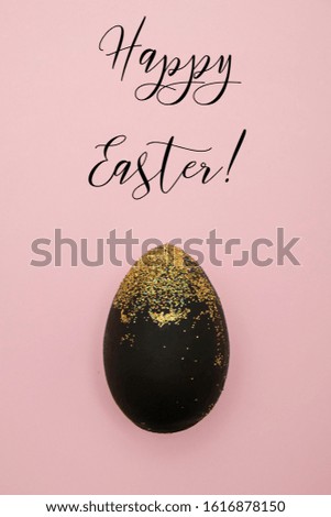 Pink greeting card for Easter with black egg and golden glitter