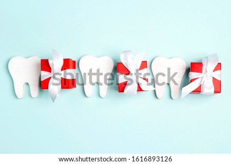 Teeth and gift boxes on a blue background. Happy Dentist's Day concept. Copy space for text.