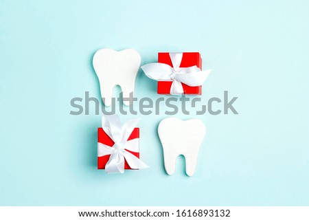 Teeth and gift boxes on a blue background. Happy Dentist's Day concept.