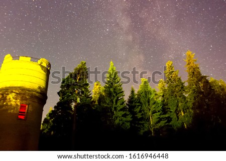 Starry sky background picture of stars in the night sky and the Milky Way. Starry sky over the forest and the water tower.