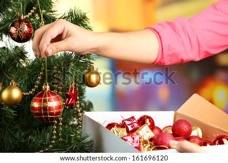 Decorating Christmas tree on bright background Royalty-Free Stock Photo #161696120