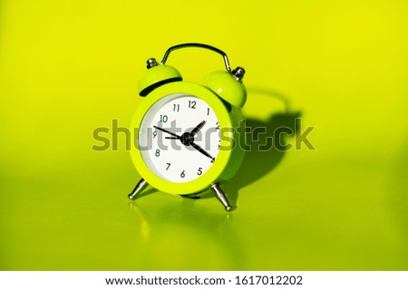 
yellow alarm clock on a yellow background close-up
