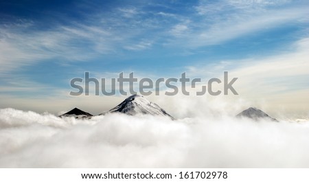 peaks of mountains above the clouds, Russia, Kamchatka Royalty-Free Stock Photo #161702978