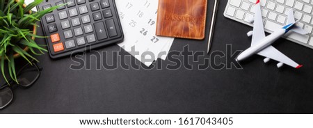 Business trip concept. Accessories on desk table. Pc keyboard, passport, calendar and airplane toy. Top view with copy space