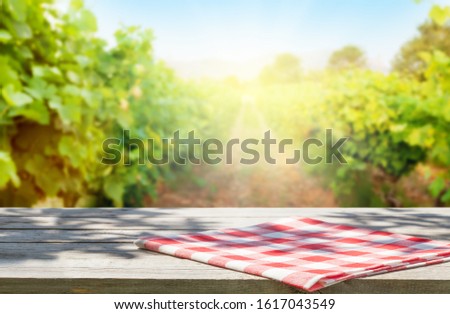 Wooden table with copy space in front of landscape of vineyard with copy space on wooden table. French countryside valley