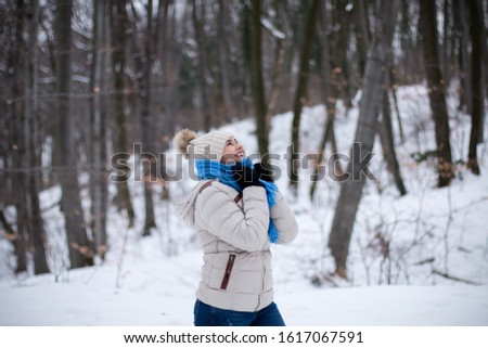 Young woman enjoying her time outdoors in the forest in winter.