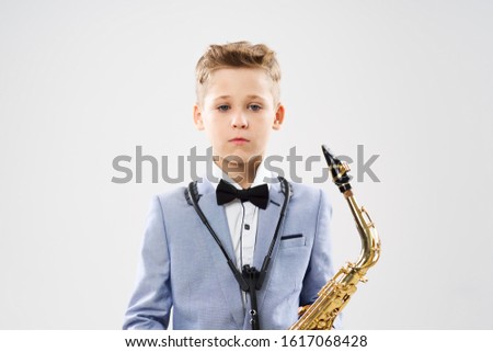 Boy musician playing a saxophone performance