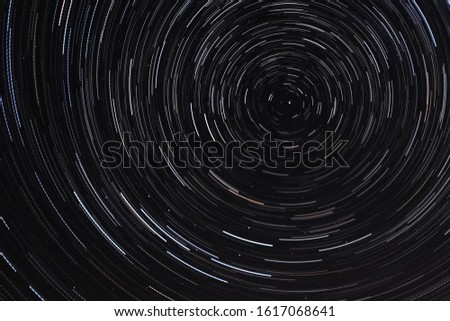 Long exposure starry sky, twisted tracks of stars. Starry sky background picture of stars in the night sky and the Milky Way.