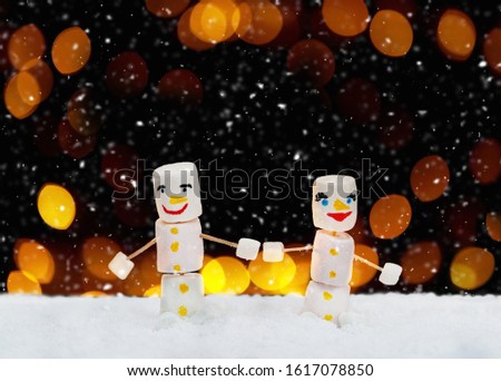 Marshmallow snowmen holding hands. Holiday concept. Christmas background with sweets.
