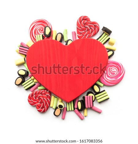 Red heart and colorful sweets, lollipops, licorice candy with copy space. View from above.