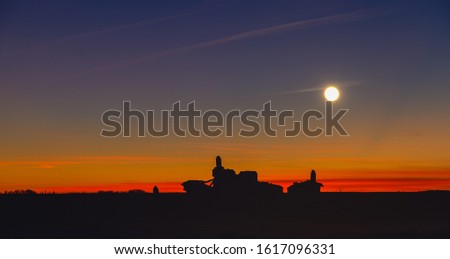 Silhouette of the remains of old dovecote at sunset with the moon in the background. Otero de Sariegos. Natural Reserve of Lagunas de Villafafila, Zamora, Spain.