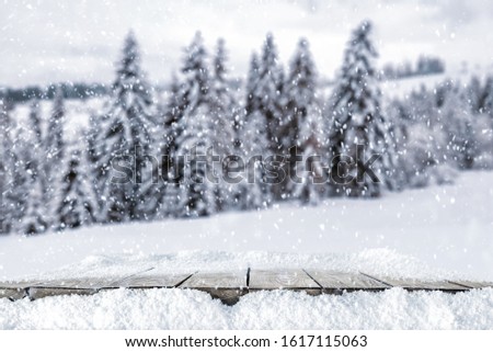 Desk of free space cover of snow and free space for your decoration.Mountains landscape and forest with frost. 