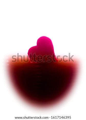 A sweet pink heart rests on a dark area. But the back has bright light.