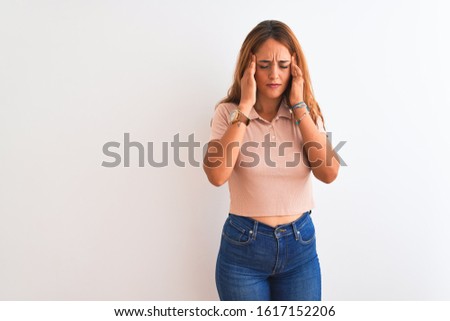 Young redhead woman stading over white isolated background with hand on head for pain in head because stress. Suffering migraine.