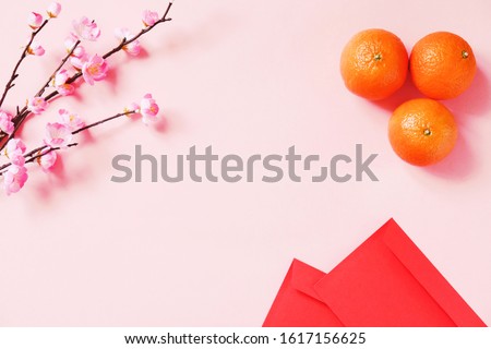 Chinese New Year background. Flat lay pink sakura, mandarins and red pockets for money. Mockup