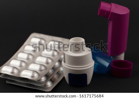 Capsule inhaler with a set of capsules on a black background. Royalty-Free Stock Photo #1617175684