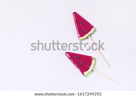 Two Tasty Red Lollipops in Shape of Watermelon on Blue Background Minimal Top View Flat Lay Tasty Candies Toned