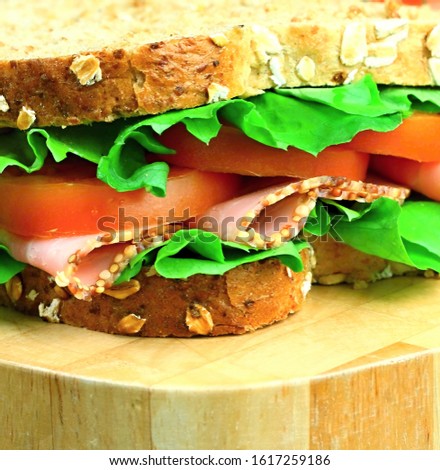 sandwich with ham and tomato on a wooden table top stock photo