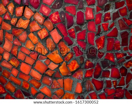 Red, orange and brown mosaic on the wall. Background. Pattern.
