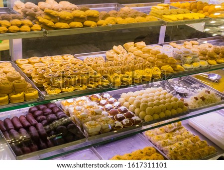 A variety of delicious Indian Bengali Sweets - gulab jamun, rasogulla, kaju barfi, kheer kadam, sandesh and laddu displayed on the street side food stall in Kolkata for sale. Royalty-Free Stock Photo #1617311101