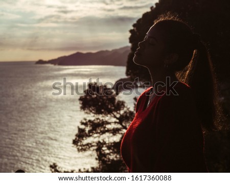 girl enjoying the sunset a backlit photo where her silhouette is marked