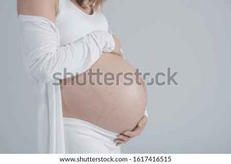 Close-up of pregnant woman with hands touch tummy ,soft picture tone.