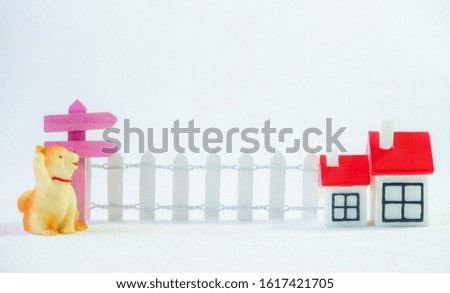 Miniature house with wooden fence, sign and dog pet for housing advertisement. Sale, rent, purchase of property business concept on white background