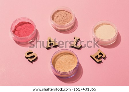 Wooden Sale word with loose pigments and powders on pink background.
