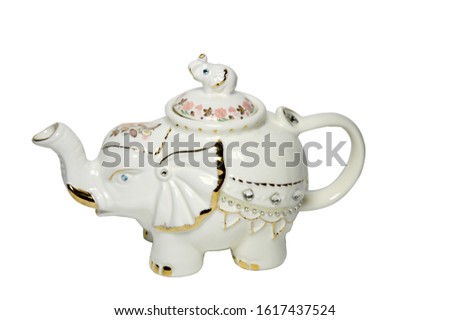 the picture shows a teapot in the form of an elephant decorated with colored stones and bright colors. drinking tea from such a teapot is very nice