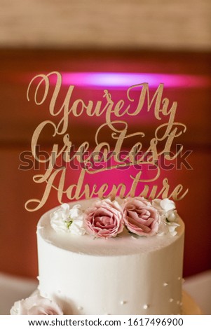 gold words topper on white wedding cake